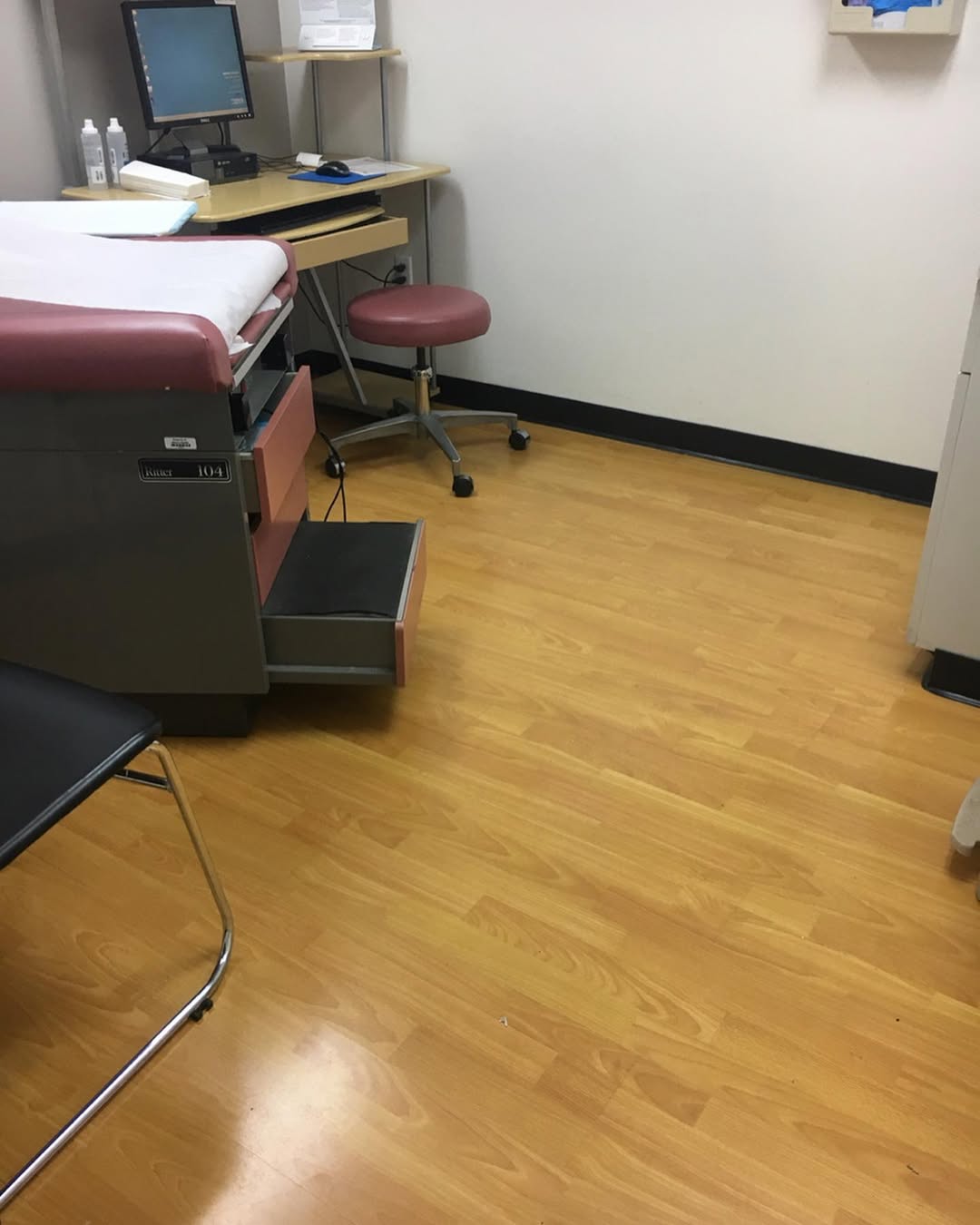 Exam room floor cleaned around medical equipment